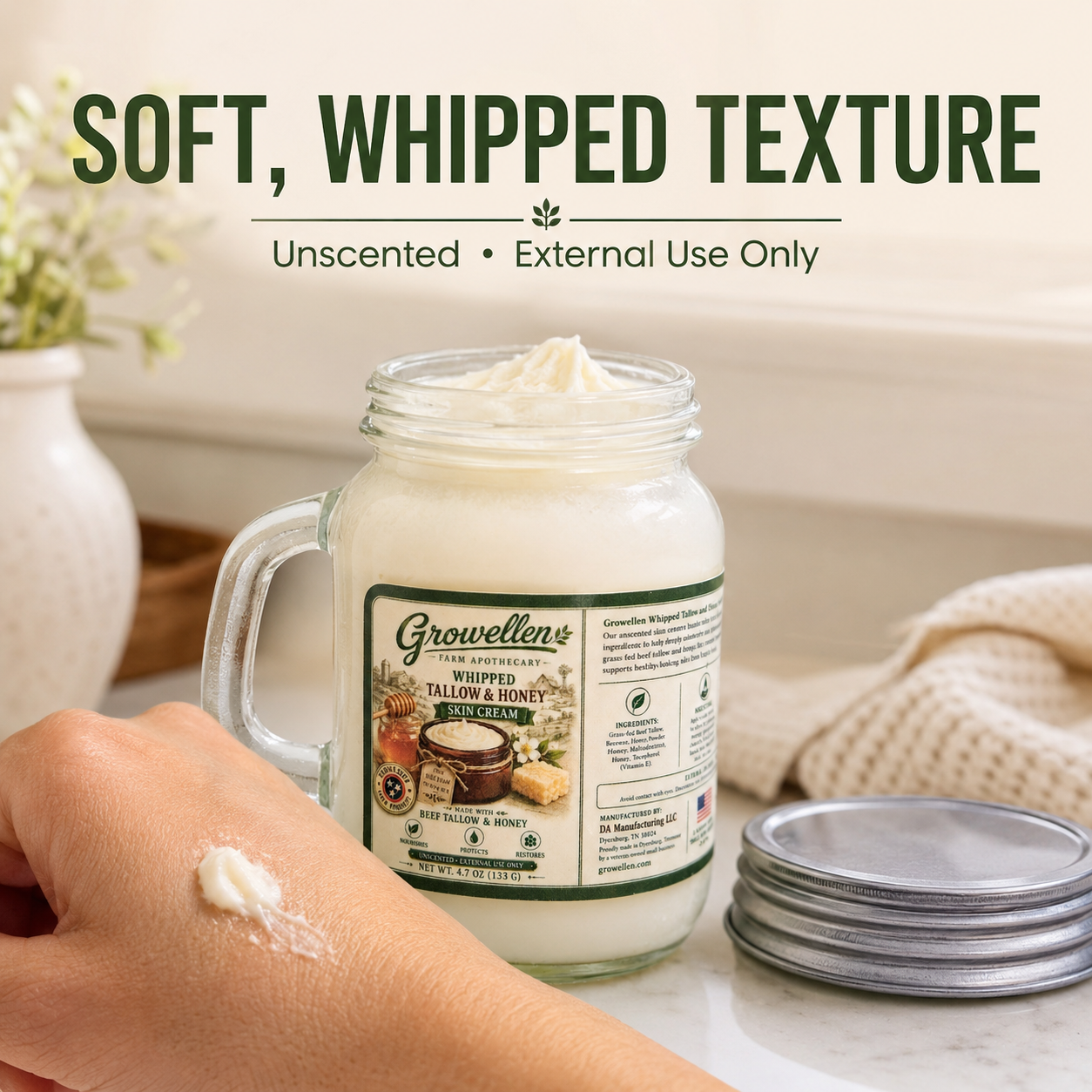 Whipped tallow and honey skin cream with a dab of cream on a hand, showing its soft whipped texture.